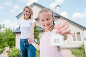 Mutter und Tochter vor dem neuen Einfamilienhaus