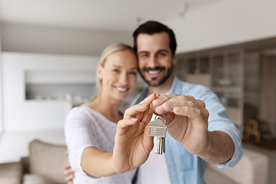 Paar mit Schlüssel zur neuen Immobilie