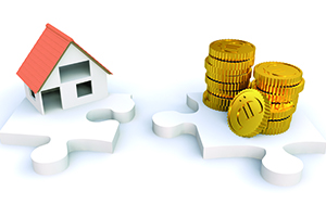 Miniatur Haus und Geld auf zwei Puzzlestücken
