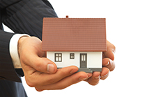 Mann hält Haus in der Hand